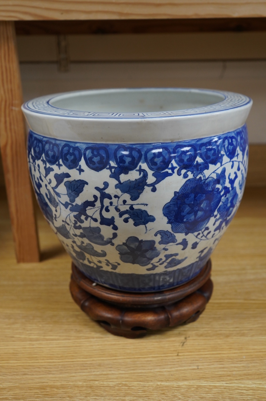 A Chinese blue and white floral jardiniere on hardwood stand, overall 32cm high. Condition - good